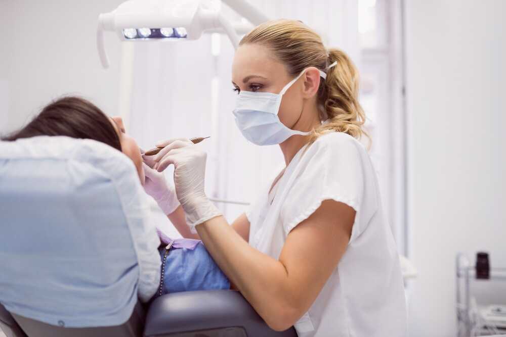 Lekarska stomatolog podczas leczenie zębów pod narkozą