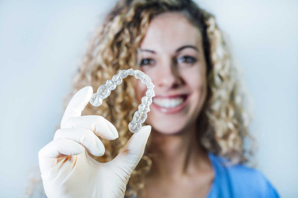 Aparat Invisalign w rękach ortodontki